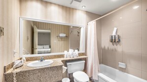 A modern bathroom with a sink, toilet, and bathtub.