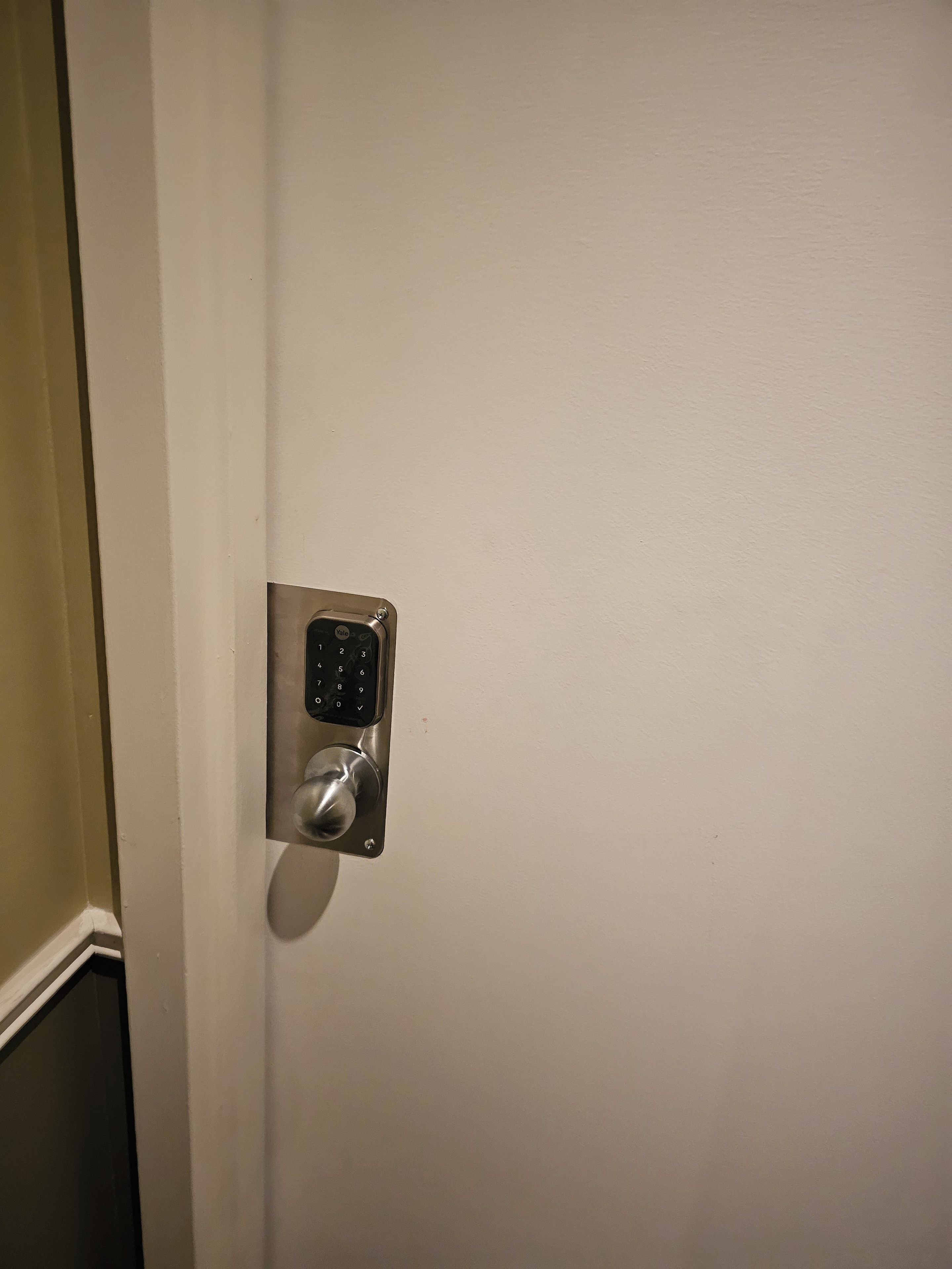 A door with a keypad lock and a keyhole.