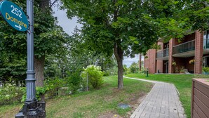 Une enseigne indiquant « 252 Domaine », avec un chemin menant à un bâtiment doté de balcons et agrémenté de plantes en pot.