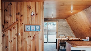 Un interno in legno con zona pranzo, una decorazione a forma di veliero e certificati incorniciati al muro.