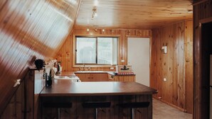Una cucina accogliente con pareti in legno e un'ampia finestra.