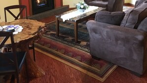 Un salon avec une cheminée, un téléviseur, un canapé et une table basse.
