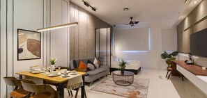 A modern living room with a dining area, a sofa, a coffee table, and a TV. - Chambers Residence Kuala Lumpur by Roam (Kuala Lumpur)