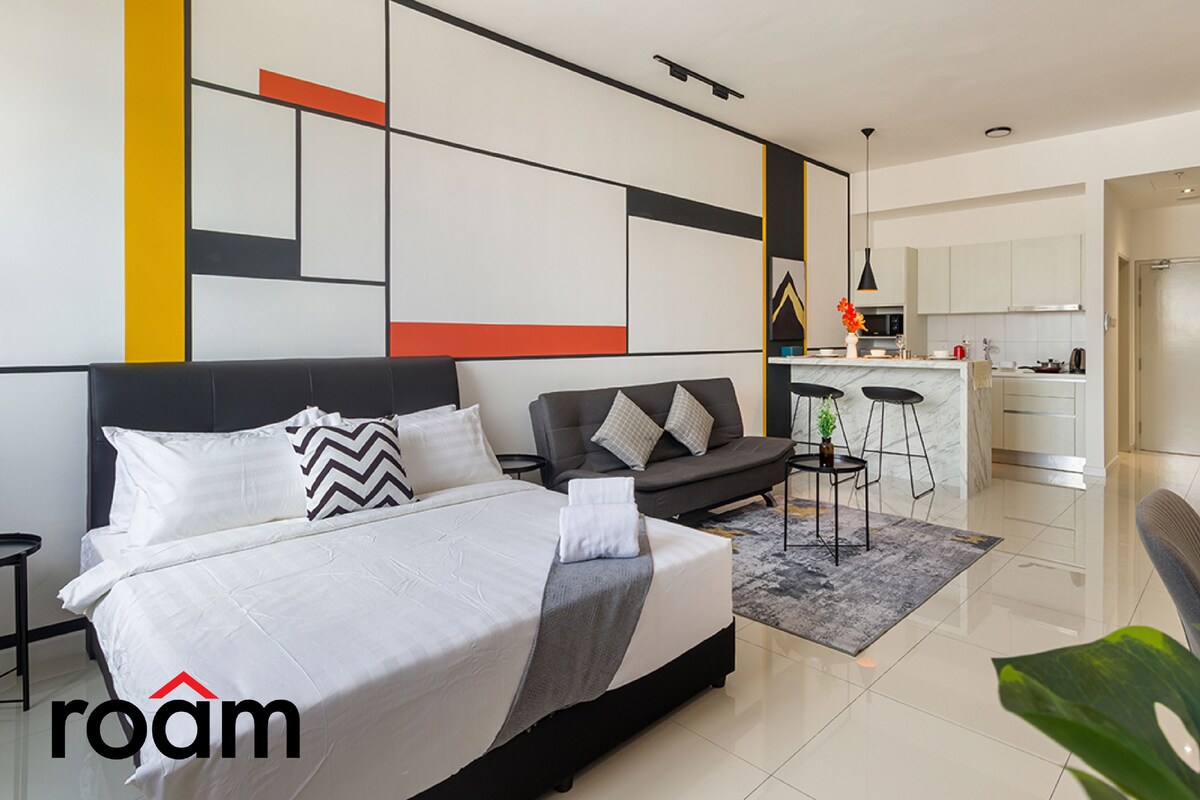Une chambre d’hôtel moderne comprenant un lit, un canapé, un coin cuisine et un espace repas.