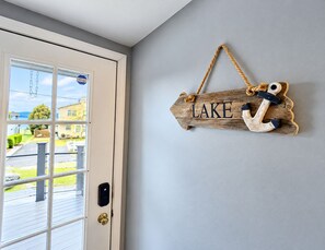 Puinen kyltti, jossa on sana ”LAKE” ja seinälle ripustettu ankkuri.