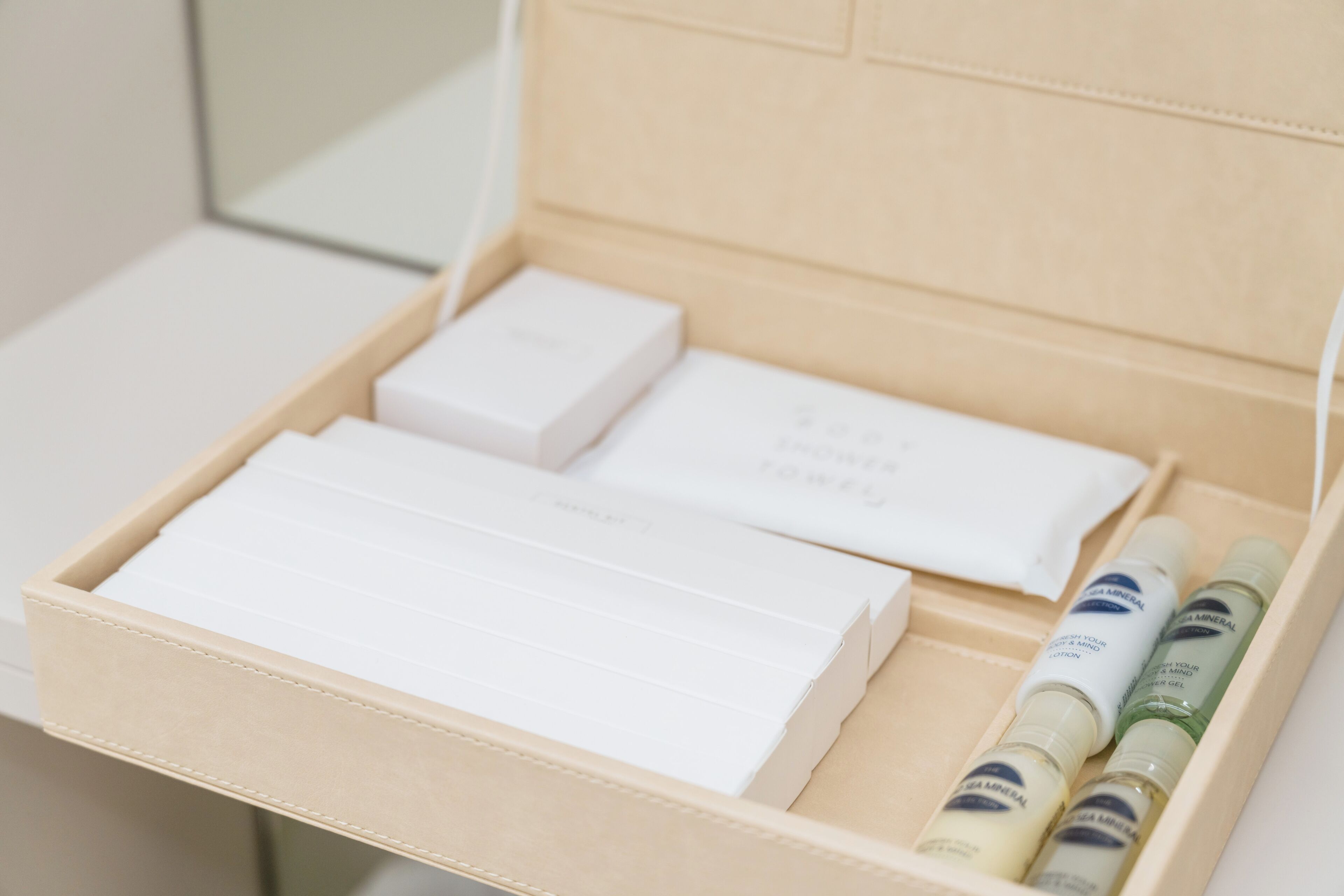 A beige box with white and green bottles, a white box, and a white rectangular object.