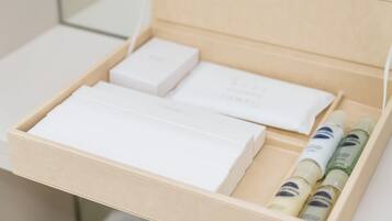 A beige box with white and green bottles, a white box, and a white rectangular object.