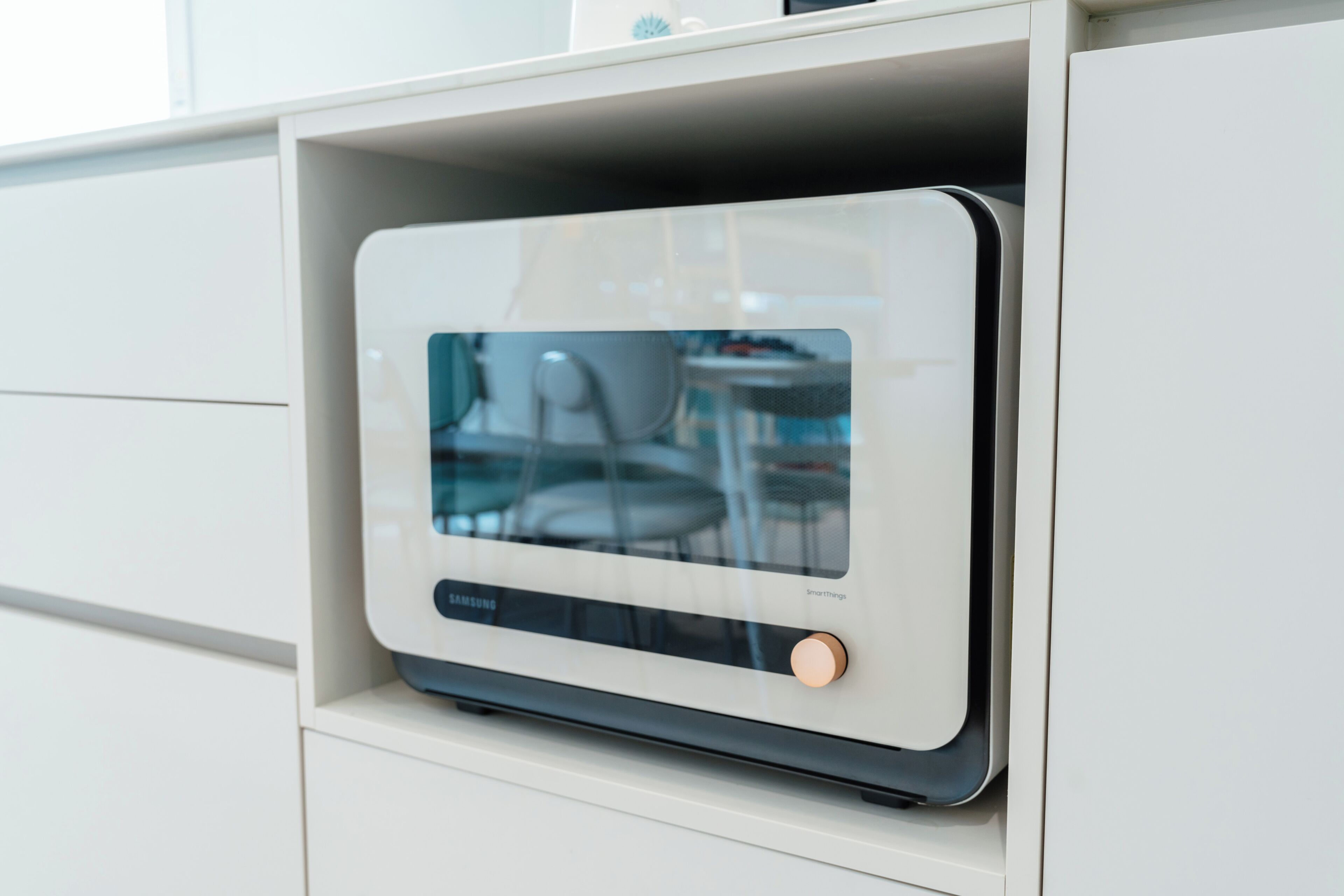 A Samsung SmartThings hub in a white cabinet.