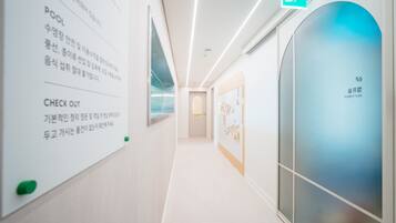 A modern hotel corridor with a clear sign indicating amenities and directions.