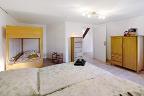 Ein Schlafzimmer mit einem Etagenbett, einem Holzschrank, einem kleinen Nachttisch und einer Lampe.