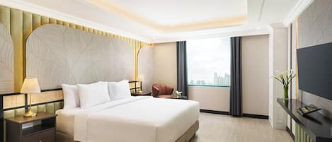 A modern hotel room with a large bed, a nightstand with a lamp, a seating area with a chair, a television on a stand, and a view of the city through the window.