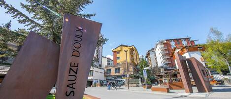 A sign with 'SAUZE DOUX' and a modern building with balconies.