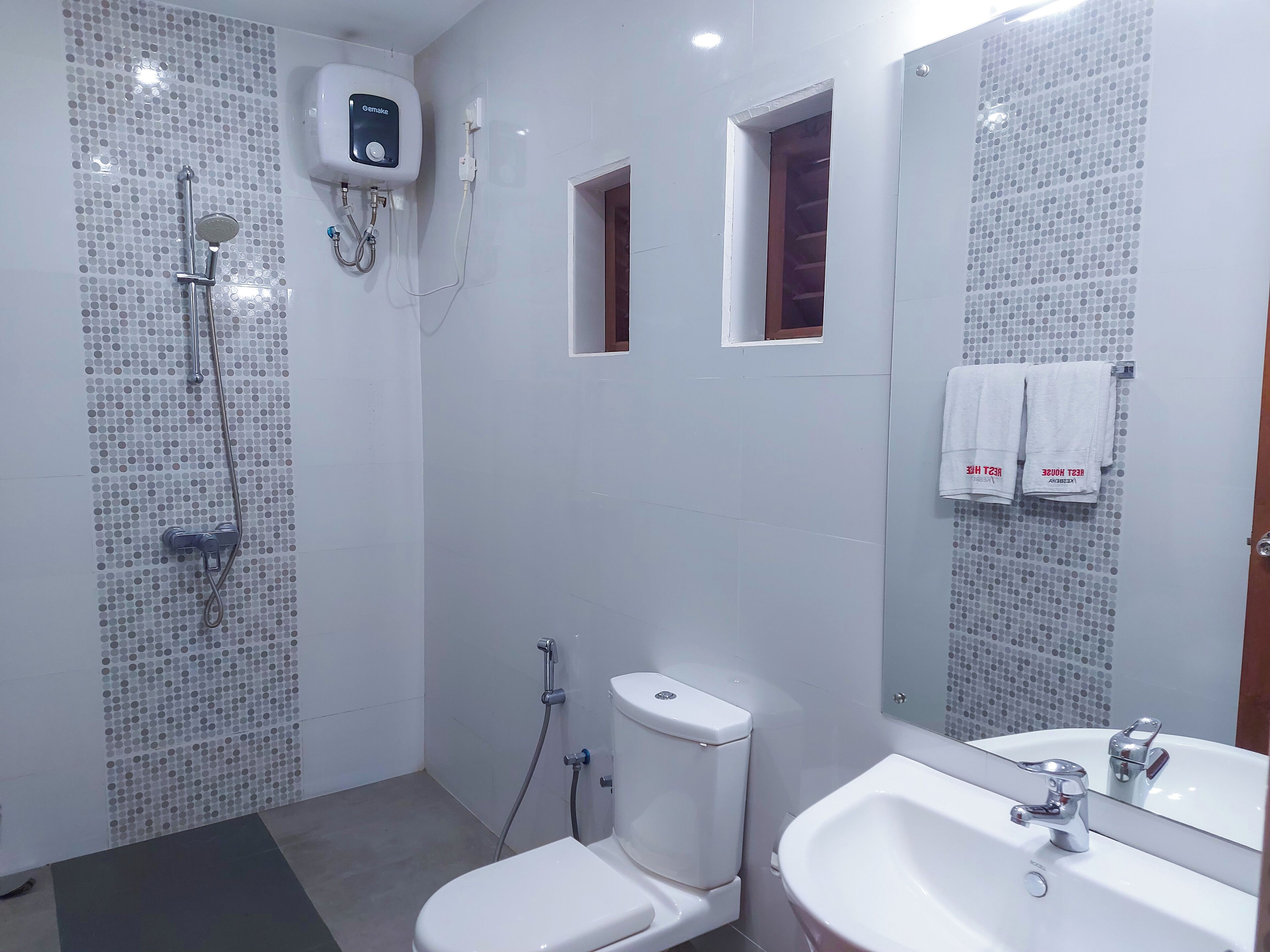 A modern bathroom with a toilet, bidet, and shower unit.
