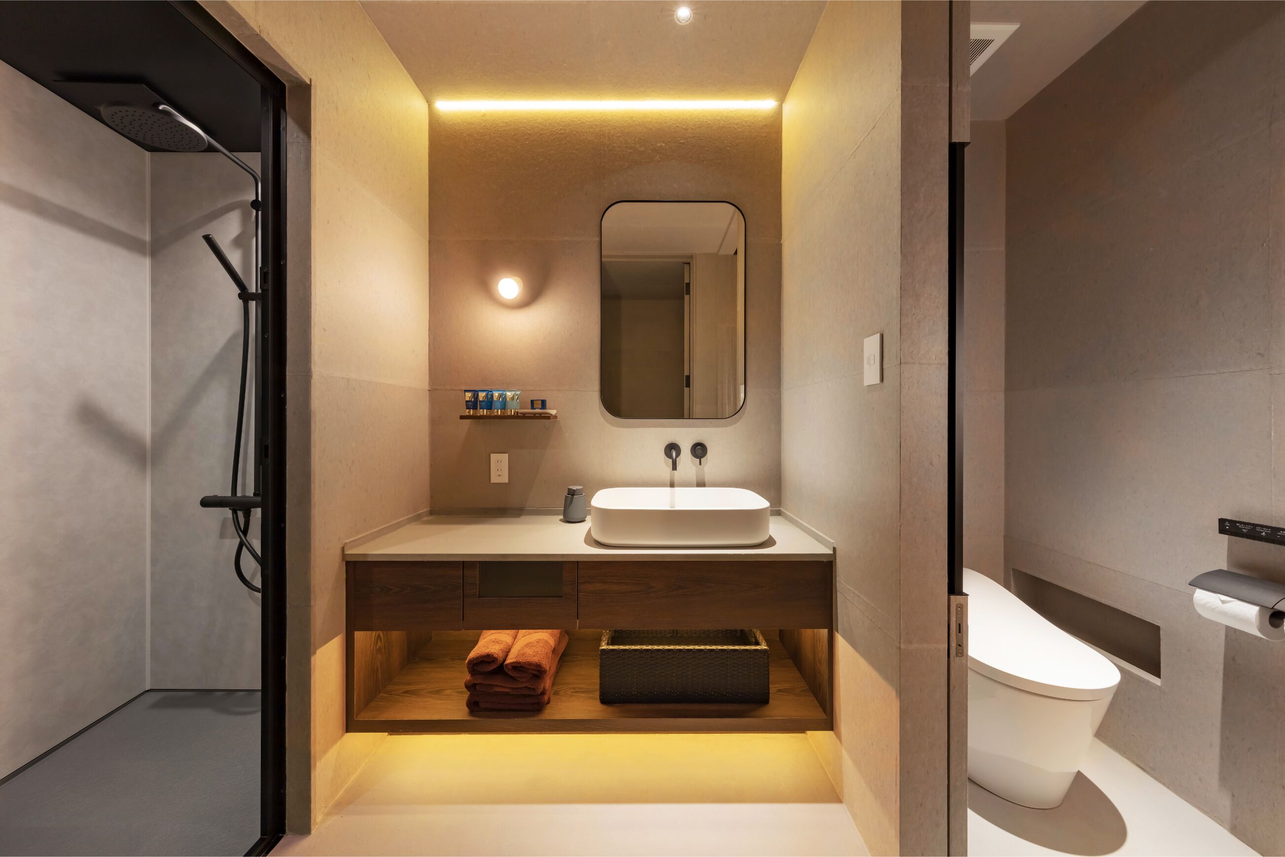 A modern bathroom with a large mirror, a sink, a toilet, and a shower area.