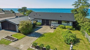 A modern house with a large patio and a view of the sea.