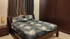 A bedroom with a bed, curtains, a nightstand, and a wardrobe. - Nice semi D house at Tangkak (Tangkak)