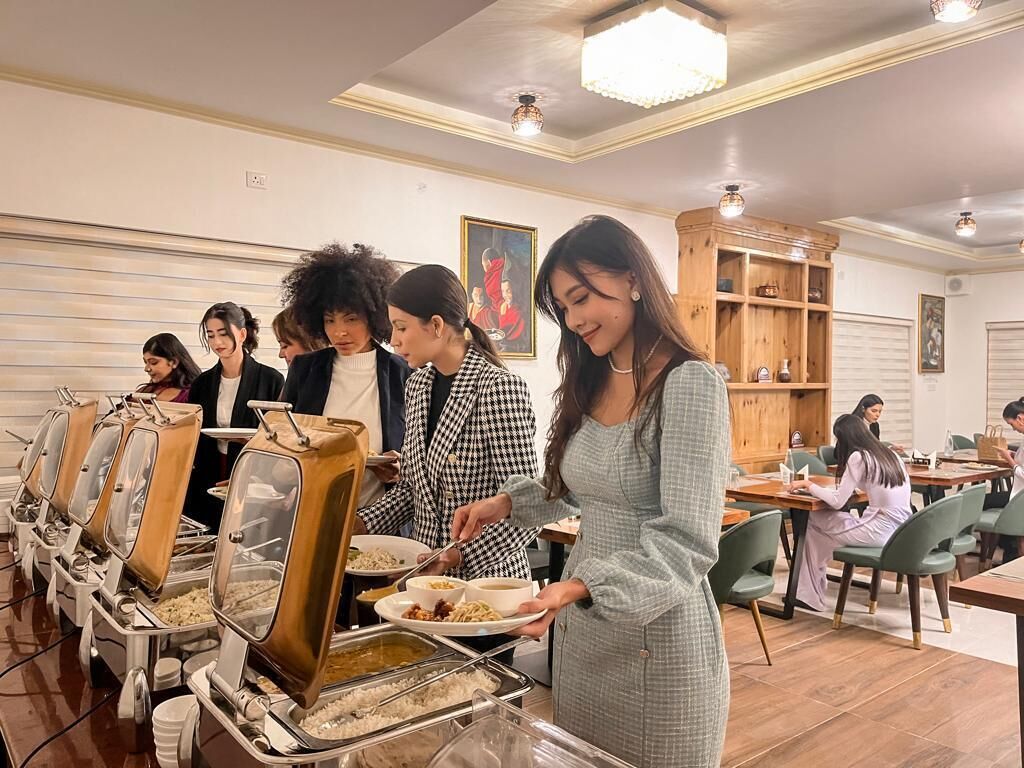 A buffet setup with multiple serving stations and guests dining.