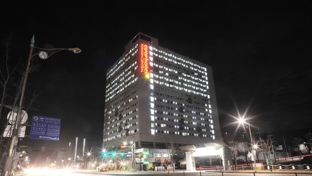 A high-rise hotel with multiple floors, illuminated windows, and a prominent sign. - Yongin Central CO'OP Hotel (Yongin)