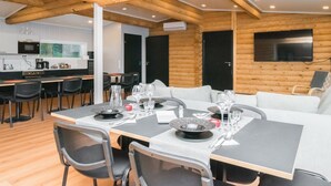 Een moderne blokhut met een eetgedeelte, keuken en woonruimte.