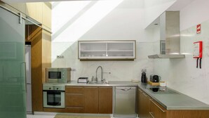 A modern kitchen with a microwave, toaster, sink, and dishwasher. - Atlantic House - Marina (Ponta Delgada)