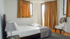 A hotel room with a bed, a desk, a chair, and a TV. - Atlantic House - Marina (Ponta Delgada)