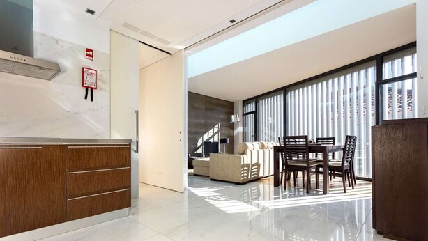 A modern kitchen with wooden cabinets and a marble countertop. - Atlantic House - Marina (Ponta Delgada)