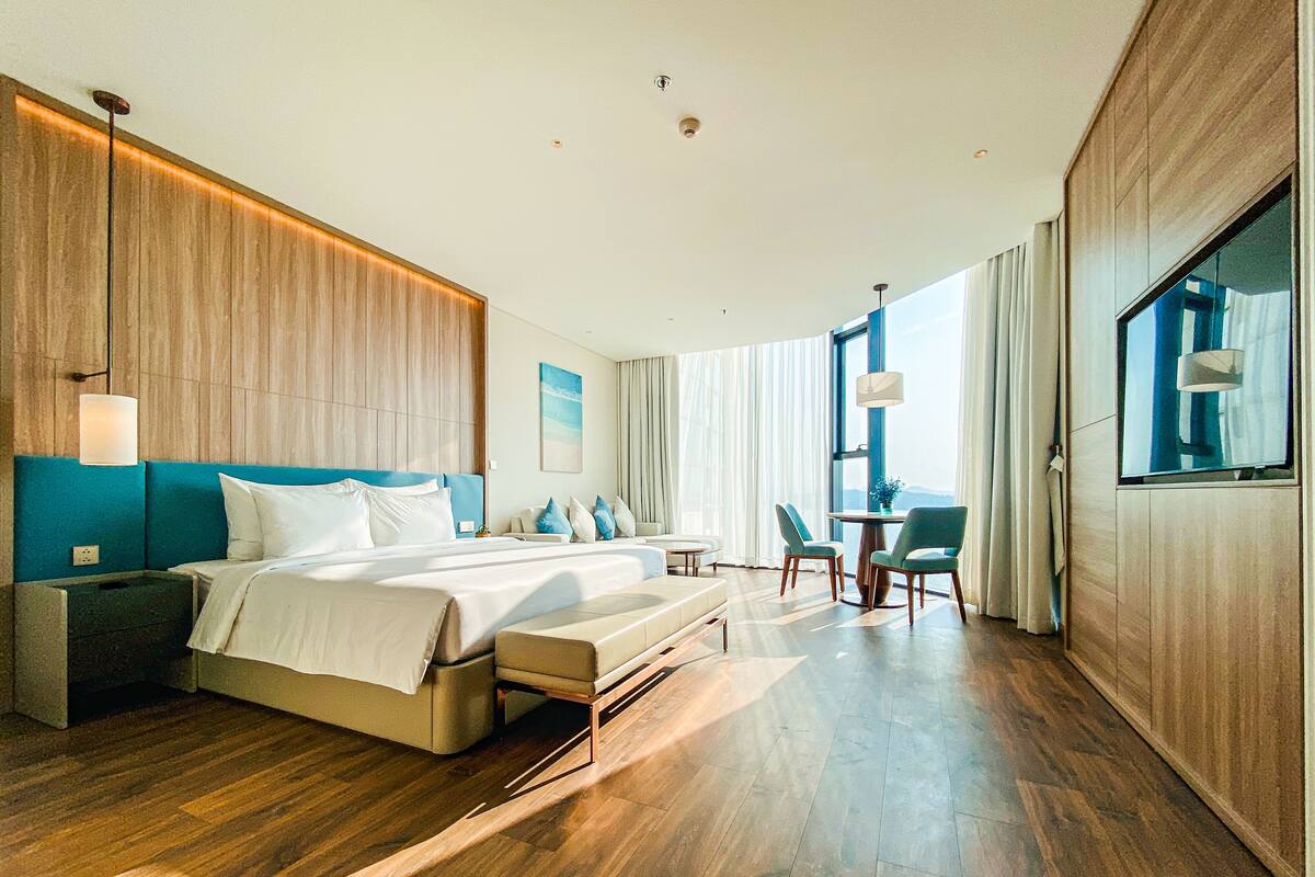 Ein modernes Hotelzimmer mit einem großen Bett, einem Schreibtisch und einer Sitzecke.