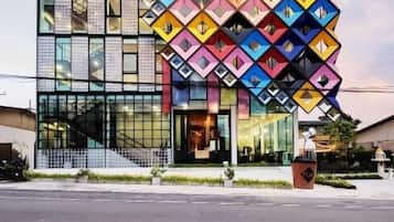 Un edificio moderno con fachada de vidrio y un llamativo patrón geométrico en la fachada.