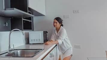 Une cuisine moderne équipée d’un four à micro-ondes encastré, d’un évier et d’un plan de travail.