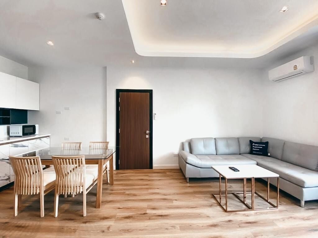 Un espacio habitable moderno con comedor, sofá y mesa de centro.