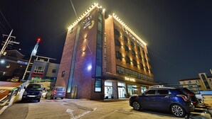 Un edifici de maó amb cartelleria il·luminada que diu "Stay Hotel".