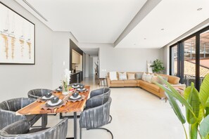 A modern interior with a dining area, a sofa, and a large window.