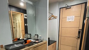 Un bagno moderno con uno specchio grande, un lavandino con articoli da toilette e uno spazio doccia.