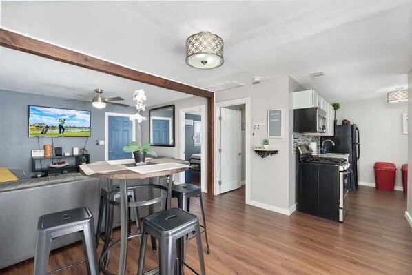 A modern kitchen with a microwave, stove, and red trash bins.