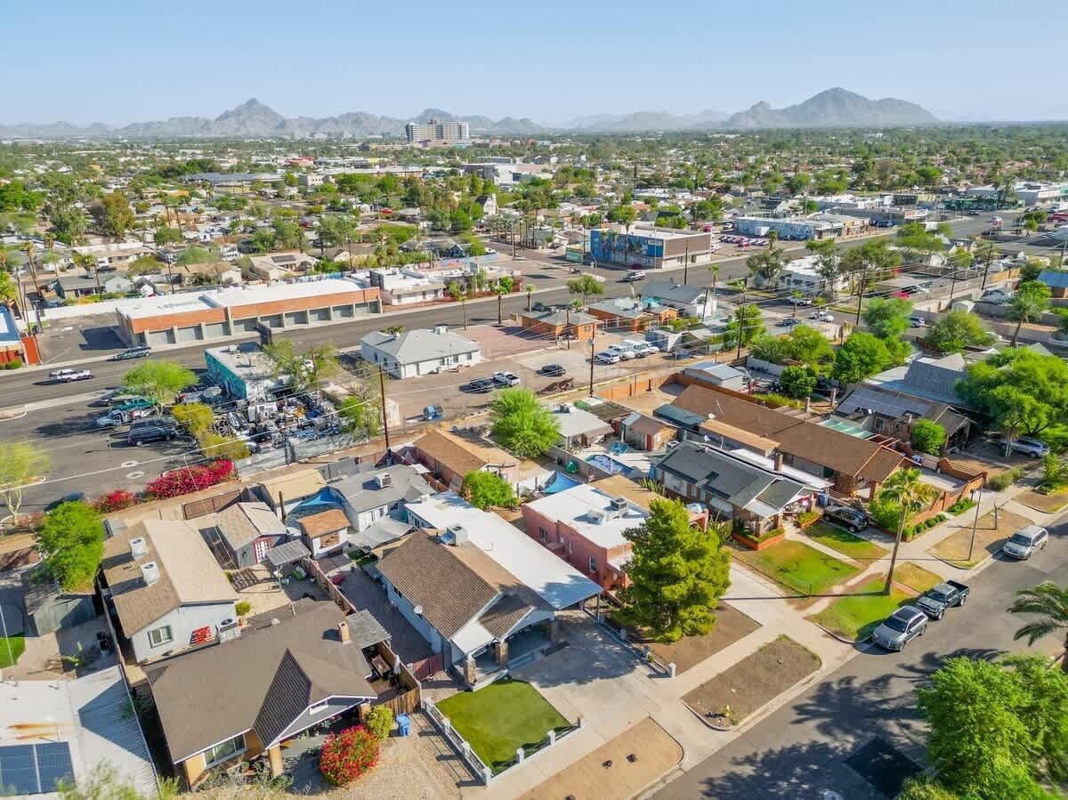A residential area with houses, streets, and a distant mountain range.