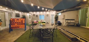 An indoor patio area with a round table and chairs, a seating area with cushions, and a decorative wall with lights. - Central Phoenix Casita w/ Beautiful Patio (Unit B) (Phoenix)