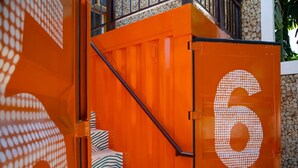 Una escalera con un manto a rayas de cebra que lleva a una puerta marcada con el número 6.