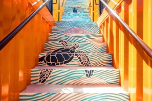 Uma escadaria com design de tartaruga nos degraus e padrão de ondas nas paredes.