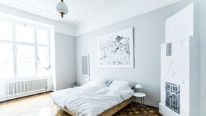 Une chambre à coucher avec un lit en bois, un mur blanc et une fenêtre.