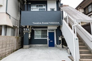 En bygning med skilt for 'Vacation Rental NISHIDA' ved indgangen.