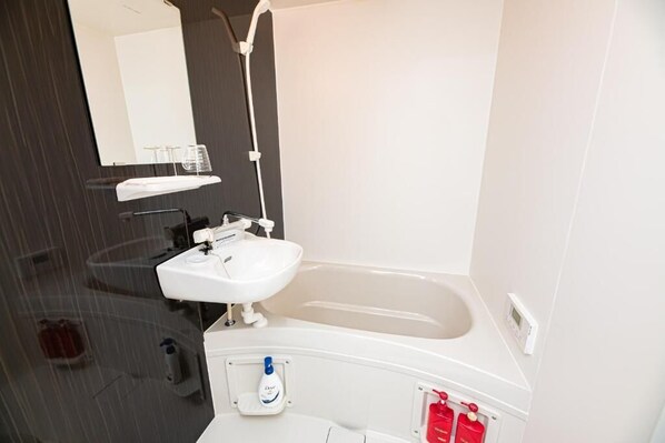 A bathroom with a white sink, a bathtub, a mirror, and a towel rack.