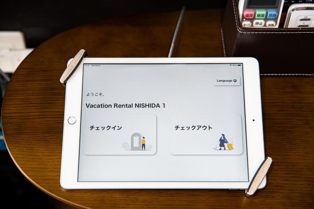 A tablet displaying a vacation rental app interface with options for check-in and check-out.