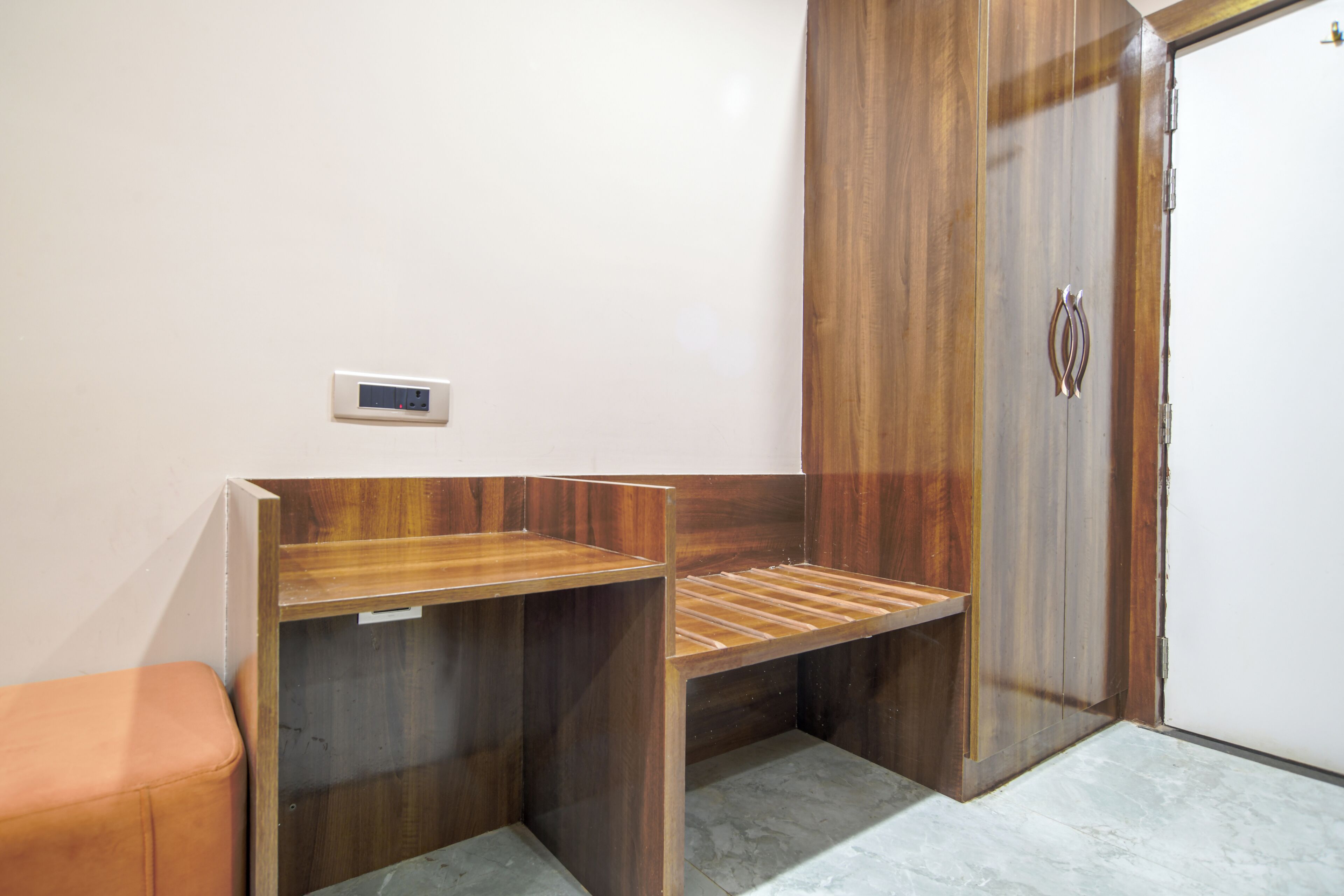 A bathroom with a wooden vanity, a towel rack, and a toilet.