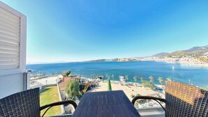 A balcony with wicker furniture overlooking a coastal view with a clear sky. - Bodrum Gulet Otel (Bodrum)