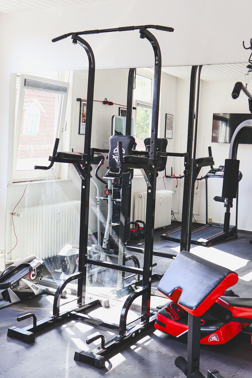 A gym with exercise equipment, a window, and a radiator.