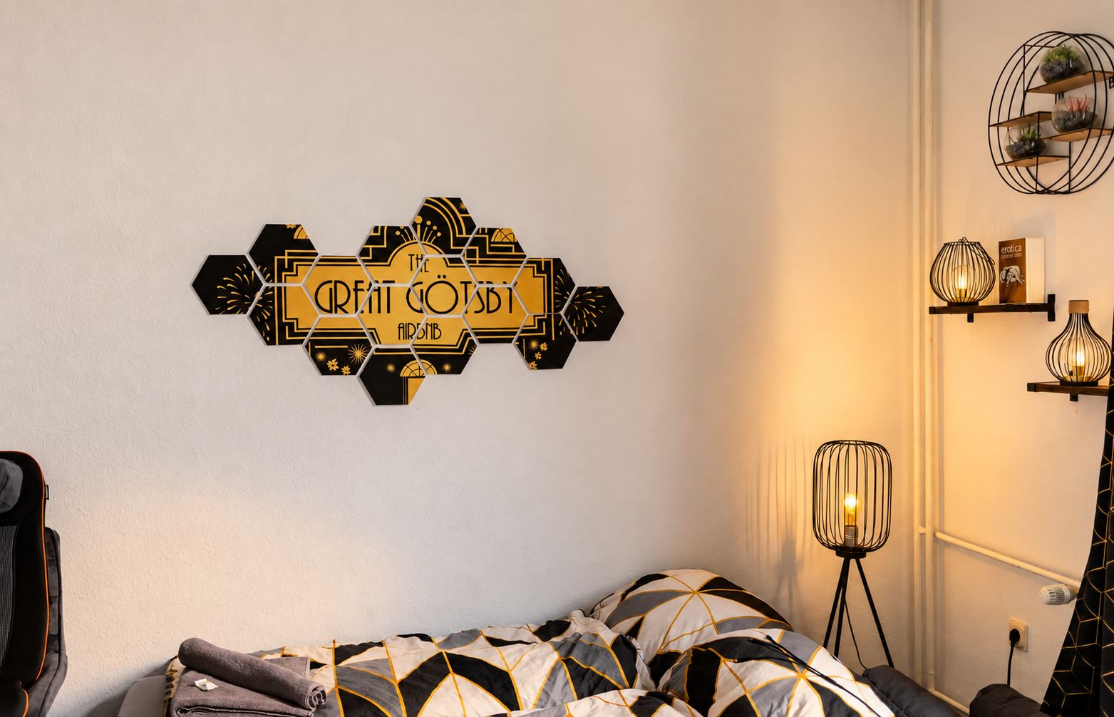 Ein Zimmer mit einem Bett, einem Wandbild, einer Lampe und einem Regal mit Dekorationsobjekten.