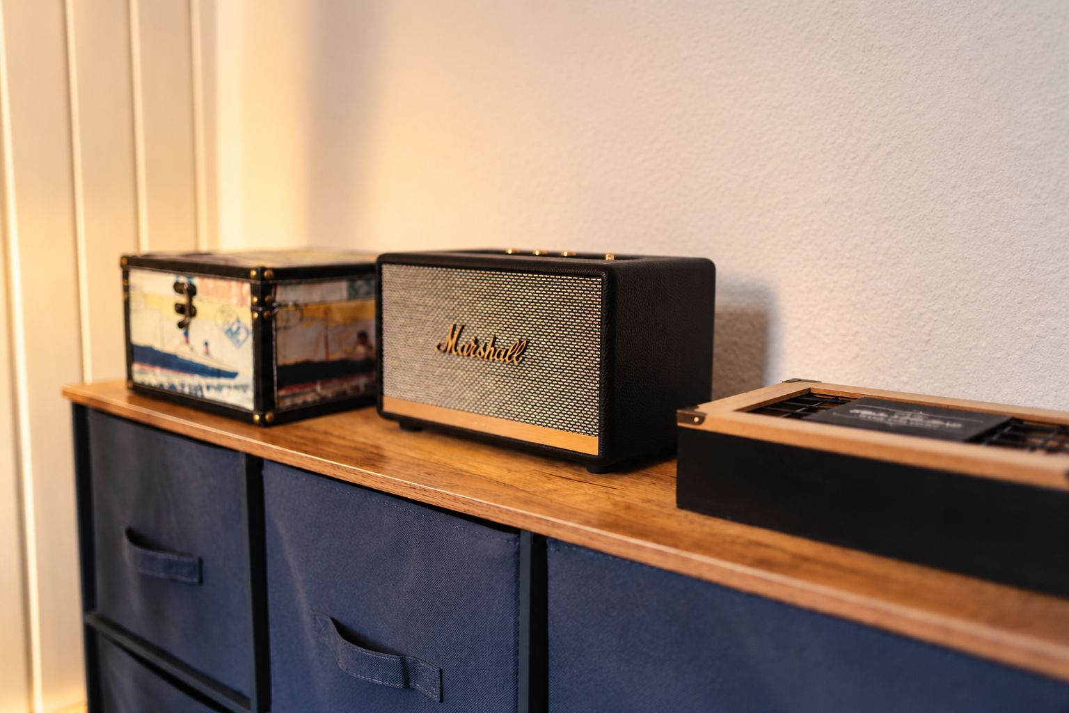 Une étagère en bois sur laquelle sont posés trois appareils audio anciens.