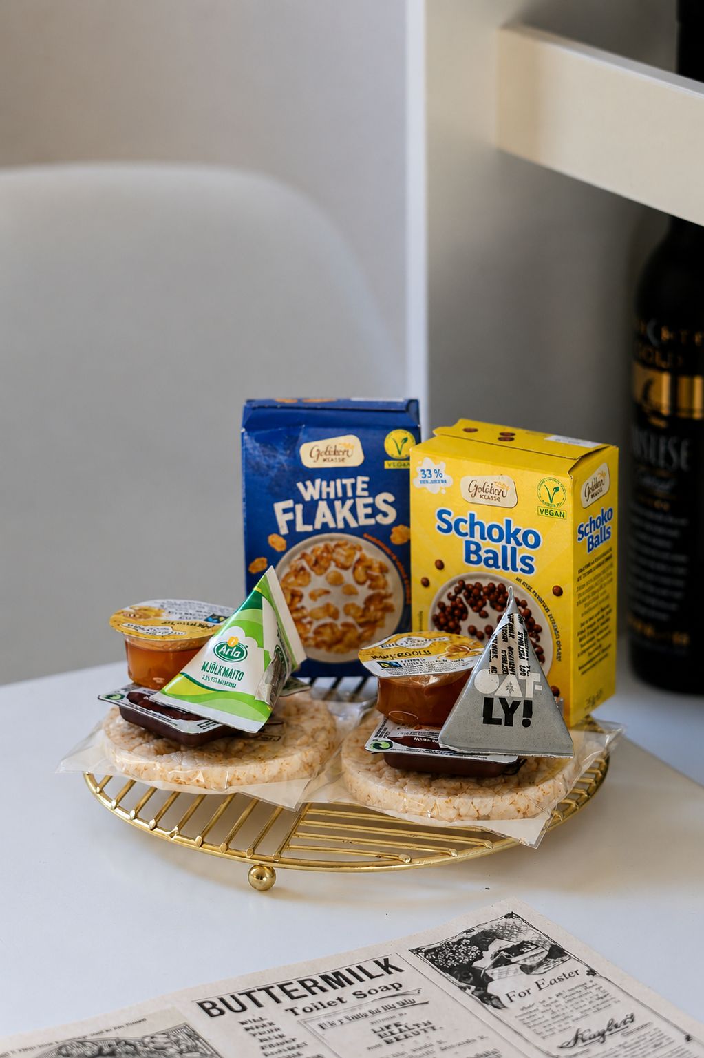 Een tafel met ontbijtproducten zoals cornflakes, een chocoladebal en een klein modelbootje.