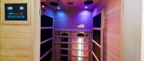 Una sauna con pareti in legno, un pannello di controllo e una finestra.