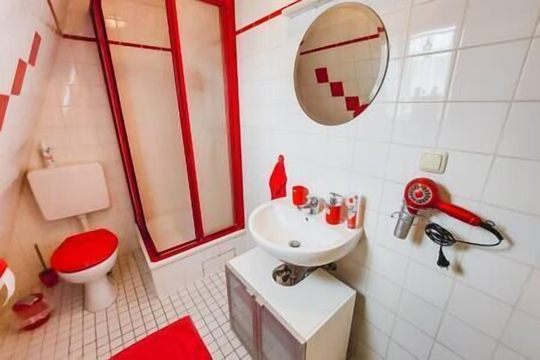 Een badkamer met toilet, wastafel en douche.